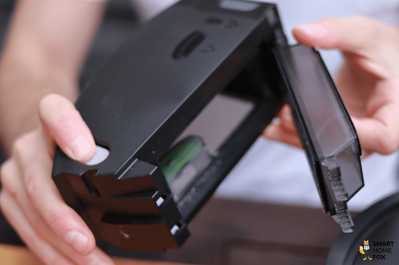 The mobile dust box of an iRobot Roomba vacuuming robot is being held.